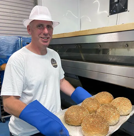 Paul at the Bakery taking cobs out of the oven.